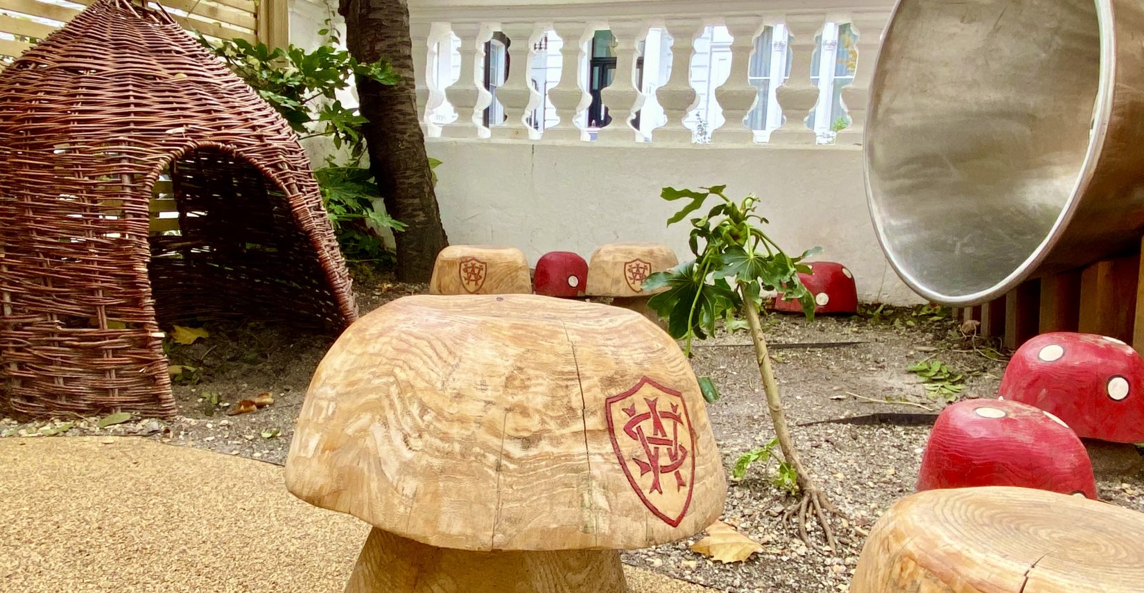 A wooden toadstool next to a wicker tent.